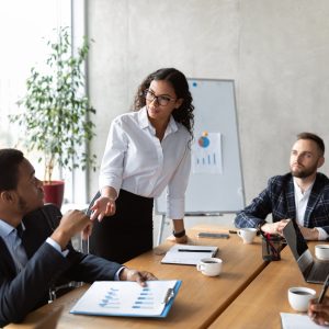 Businesswoman On Business Meeting Talking With Colleagues Standing In Office